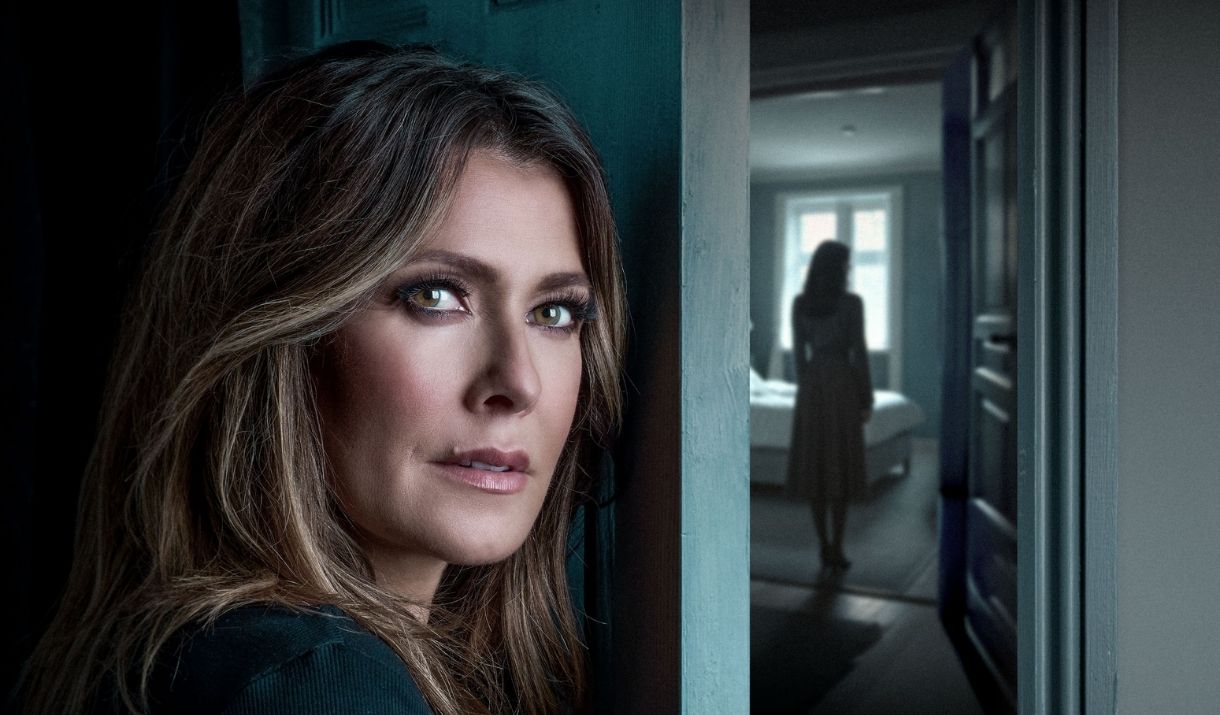 a woman hiding behind a door, with a shadowy figure in the hallway